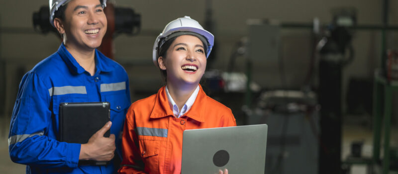 portrait-asian-emgineer-male-female-technician-safty-uniform-standing-turn-around-look-camera-laugh-smile-with-cheerful-confident-machinery-factory-workplace-background